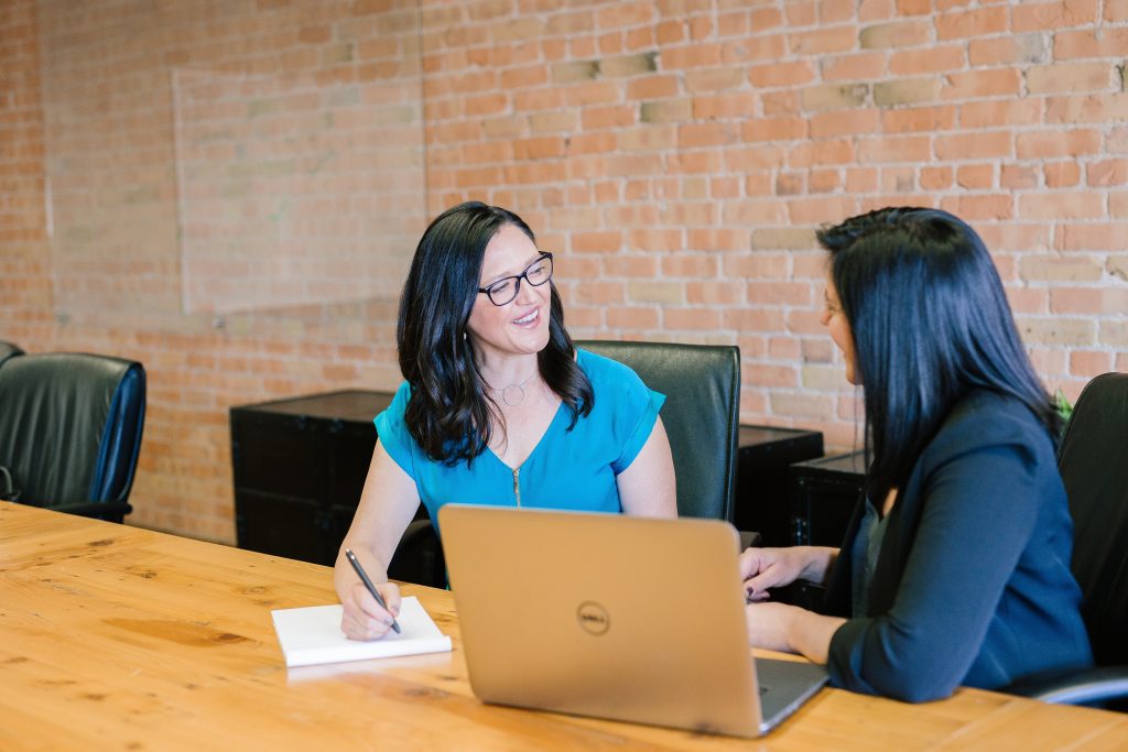Two women meeting at a table with a laptop